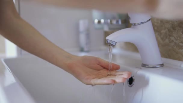 Nainen pesee kätensä hanan alla aamulla heräämisen jälkeen lähikuva
 - Materiaali, video