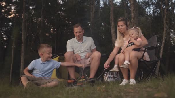 νεαρή οικογένεια χαλαρωτικό μέσα σε σκηνή για κάμπινγκ διακοπών - Πλάνα, βίντεο