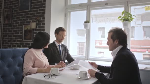 Three freelancers signing up contract documents and shaking hands. - Filmagem, Vídeo