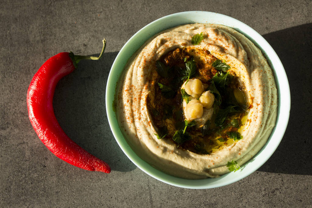 Plate of fresh homemade hummus with pita bread on the table. Authentic food of Middle East. Healthy eating concept. Vegan balanced dish. Traditional meal of Israel.   - Фото, изображение