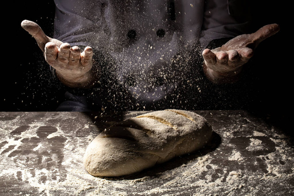 Hacer masa con las manos masculinas sobre el fondo de la mesa de madera. Proceso de fabricación de pan español
. - Foto, Imagen