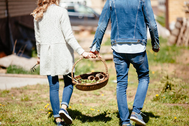 young couple carries a basket with seedlings in casual clothes - Photo, image
