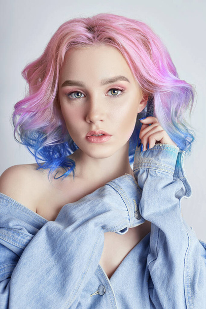 Portrait of a woman with bright colored flying hair, all shades of purple. Hair coloring, beautiful lips and makeup. Hair fluttering in the wind. Sexy girl with short  hair. Professional coloring - Foto, imagen