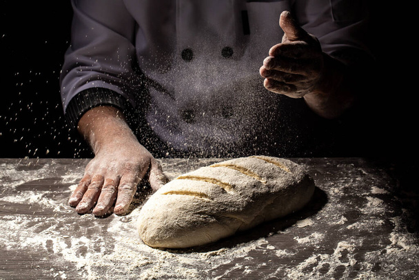 Baker making patterns on raw bread using a knife to shape the dough prior to baking. Manufacturing process of spanish bread. Food concept. - Photo, Image