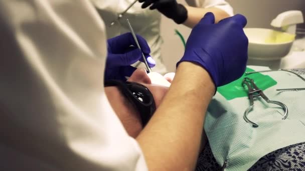стоматолог проводить лікування в ротовій порожнині
 - Кадри, відео