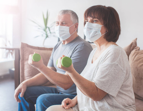 Elderly couple in medical masks during the pandemic coronavirus doing - Photo, Image