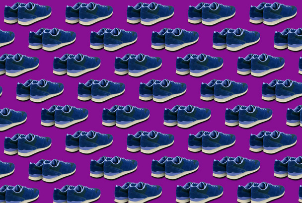 Trendy colorful pattern made with blue sport shoes on bright violet background. Minimal, beauty and fashion concept. - 写真・画像
