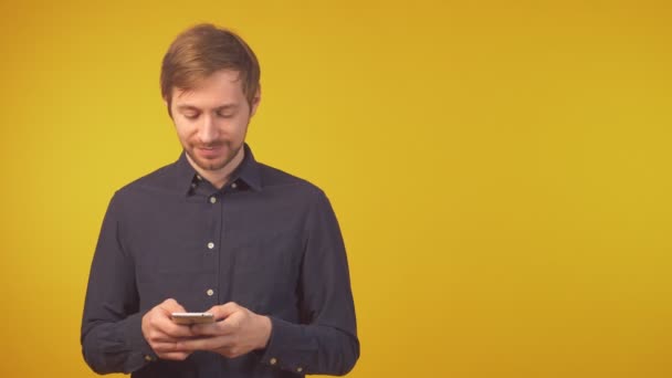 Portrét usmívajícího se mladého muže pomocí smartphonu, kopírovací prostor - Záběry, video