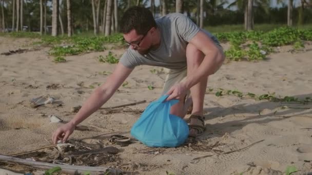 człowiek zbiera na wybrzeżu niedegradowalne odpady - Materiał filmowy, wideo