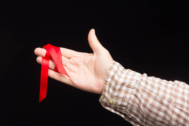 Ribbon to decorate gifts in the hand of an adult person on a plain background. - Foto, afbeelding