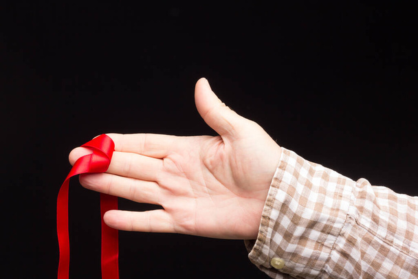 Nastro per decorare regali in mano a una persona adulta su uno sfondo semplice
. - Foto, immagini