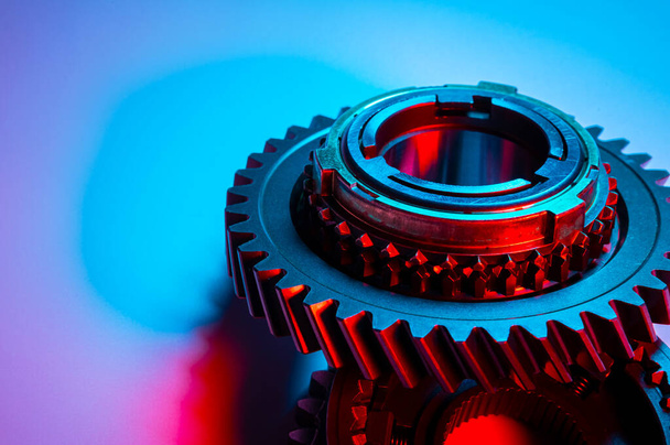 New metal gears spare parts for gearbox in two colors red and blue. Conceptual image of the mechanical elements of the transmission - Фото, изображение