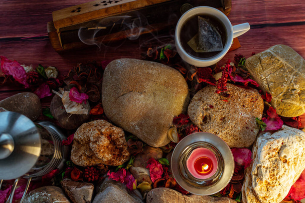 Descanso relajante con té, varilla de incienso y vela aromática en la colorida mesa y decoraciones naturales
 - Foto, imagen