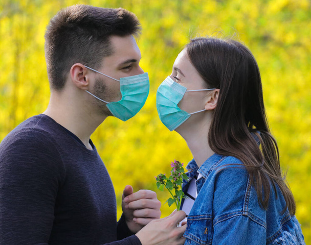 Liebe in einer Zeit covid-19 Ausbruch, Junge und Mädchen mit medizinischen Masken - Foto, Bild