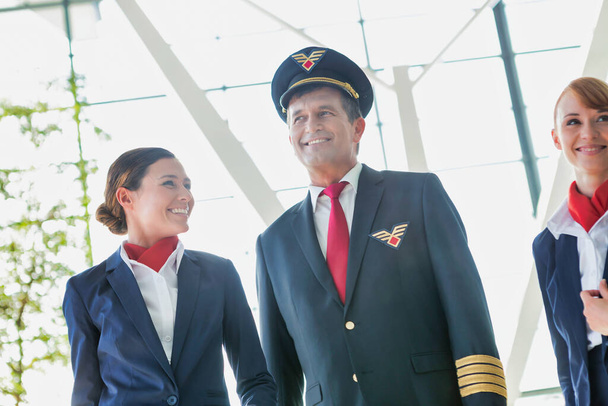 Pilot with flight attendants walking in the airport - Foto, immagini