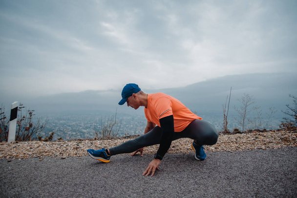 Dojrzały muskularny mężczyzna ubrany w strój sportowy przygotowujący się do ćwiczeń joggingowych - Zdjęcie, obraz