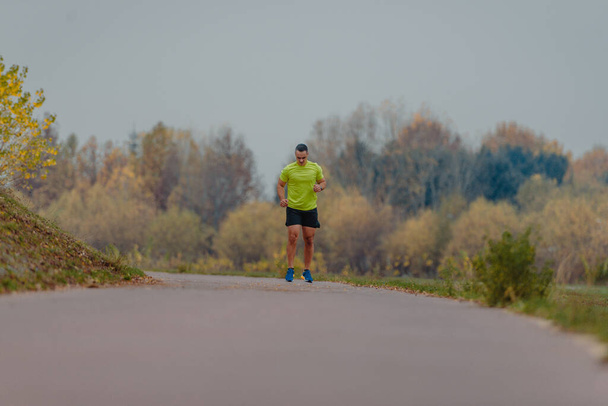 Atletický starší muž ve sportovním oblečení běží venku - Fotografie, Obrázek