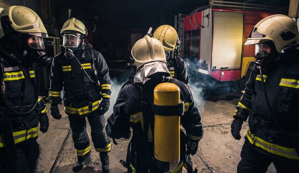 Grupa strażaków w straży pożarnej sprawdza sprzęt do masek gazowych - Zdjęcie, obraz