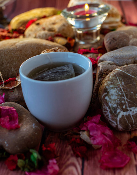 Ontspannende pauze met thee, wierookstokje en aromatische kaars op de kleurrijke tafel en natuurlijke decoraties - Foto, afbeelding
