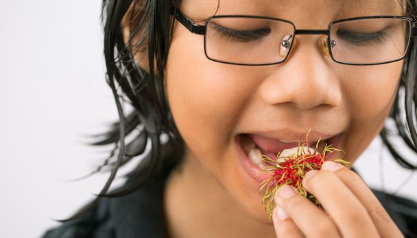 маленької дівчинки їдять фрукти рамбутан - Фото, зображення