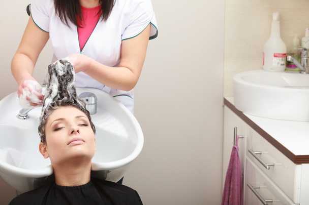 Hairstylist washing woman hair. Hairdressing beauty salon - 写真・画像