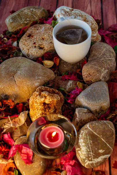 Χαλαρωτικό διάλειμμα με τσάι, θυμίαμα ραβδί και αρωματικό κερί στο πολύχρωμο τραπέζι και φυσικές διακοσμήσεις - Φωτογραφία, εικόνα