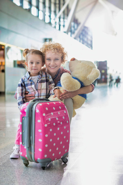 Portrait of mother reuniting with her daughter in airport with lens flare - Fotoğraf, Görsel