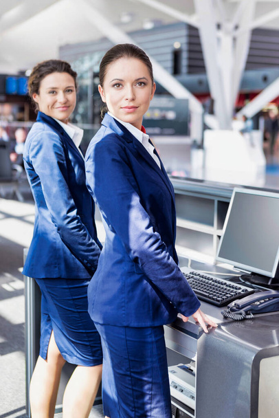 Portrait of young attractive passenger service agents standing in airport - Foto, Imagen