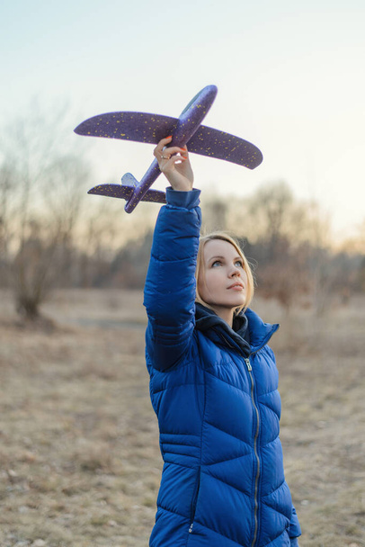 A woman launches a toy plane in nature. - Фото, зображення