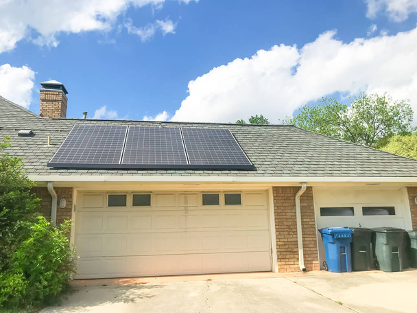 Typical three garage door residential house with solar panel on shingle roof in Dallas, Texas, USA - Photo, Image