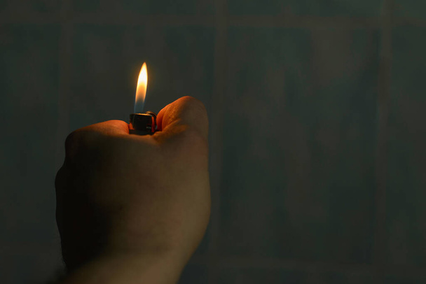 Fire lighter in male hand in the dark. - Photo, Image