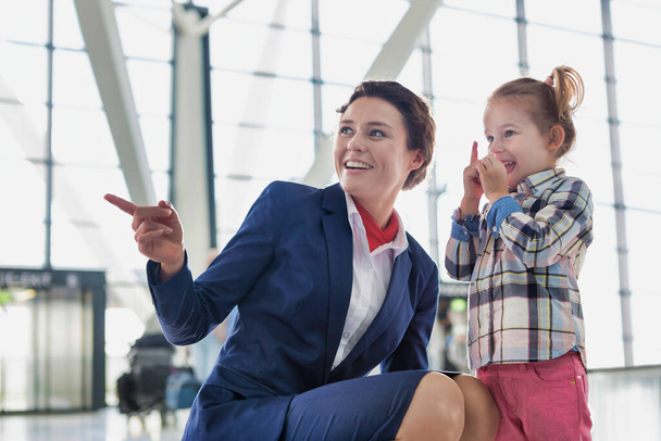 Portrait of airport staff playing with cute little girl in airport - Фото, изображение