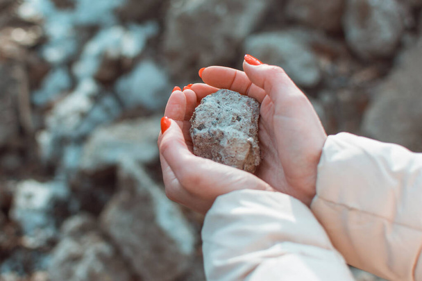 Female hands hold a stone. - Zdjęcie, obraz