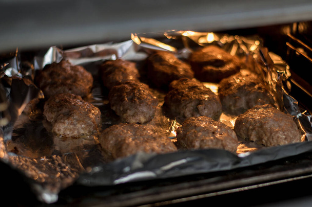Roasting meat cutlets in the oven. - Фото, изображение