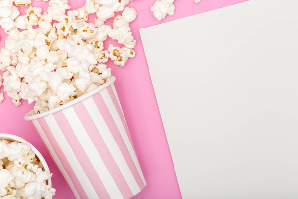 Popcorn emmer op roze achtergrond. Film of tv-achtergrond. Bovenaanzicht Kopieer ruimte - Foto, afbeelding
