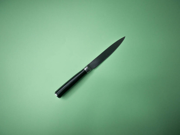 Professional kitchen knife isolated on green background. - Fotó, kép