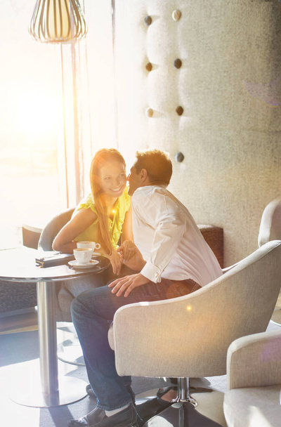 Portrait of Businessman sitting and whispering to his girlfriend in coffee shop - Φωτογραφία, εικόνα