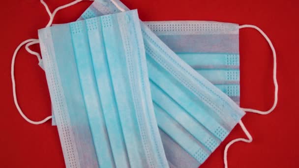 antiviral medical mask for protection against coronavirus. Surgical protective mask. Medical respiratory bandage face on red background. prevention of the spread of virus and pandemic COVID-19. - Filmmaterial, Video