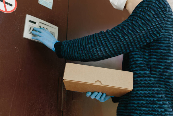 宅配便,保護マスクの配達人は安全にコロナウイルスの流行中にドアに茶色の箱でオンライン購入を提供します, COVID-19.家にいて安全なコンセプト - 写真・画像
