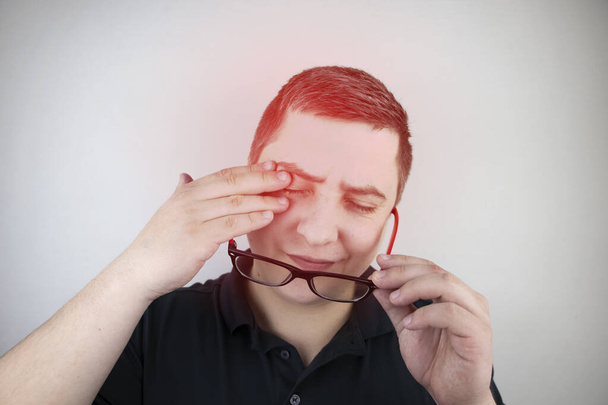 Чоловік потирає втомлені очі руками на білому тлі. Поняття втоми очей від комп'ютера і втоми від роботи. Біль в очах і лобі, мігрень, хвороби очей
 - Фото, зображення
