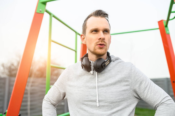 An athletic guy in hoodie and with headphones - Foto, Imagem