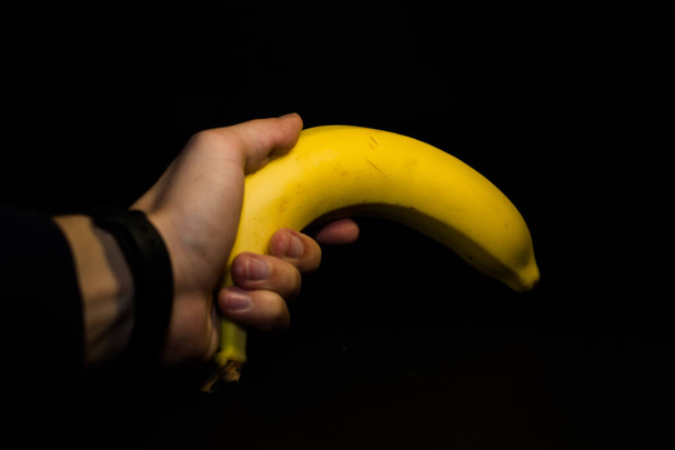 Keltainen kypsä banaani mustalla pohjalla
 - Valokuva, kuva