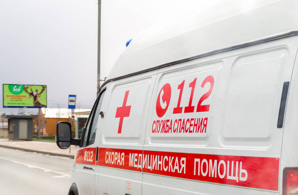 モスクワ、ロシア- 2020年4月19日:都市道路上のロシアの救急車の閉鎖、コロナウイルスの世界的なパンデミック。サイドビュー。車の碑文、翻訳:救急車、 112救助サービス - 写真・画像