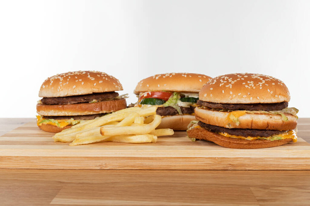Delicious juicy cheeseburger on wooden plate  - Fotó, kép