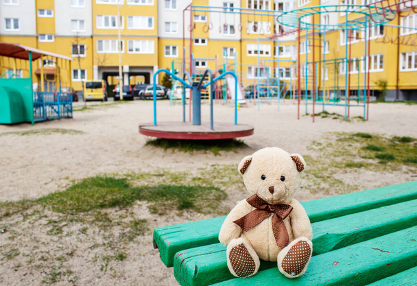 jouet oublié ours en peluche assis sur le banc dans l'aire de jeux vide en quarantaine le jour ensoleillé du printemps
 - Photo, image