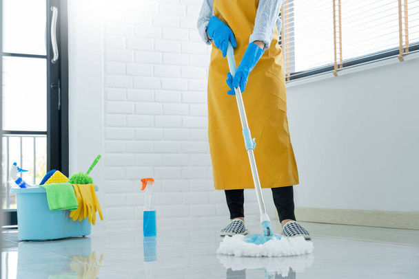Жінка-домогосподарка з мопедом і відром з миючими засобами для прибирання підлоги вдома, Послуги по догляду за підлогою і прибиранню підлоги
  - Фото, зображення