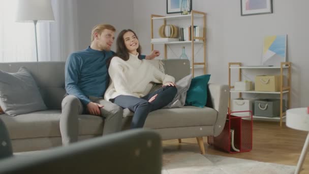 Young Couple Use Augmented Reality, Swiping and Choosing Media Content to Watch in their Living Room. Girlfriend and Boyfriend. For Motion Tracking Video Editing, Tracking Points Added on Furniture - Materiał filmowy, wideo