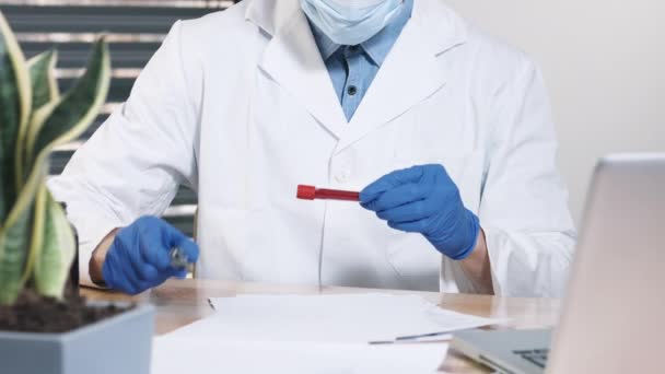 Hand of a doctor holding blood sample - Felvétel, videó