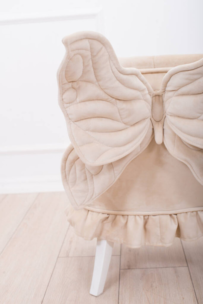 Cute beige soft chair with wings for the little princess's nursery. Children's furniture. Furniture for little girls - Foto, Bild