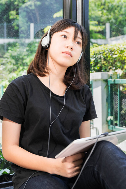 Boldog tizenéves nő hallgat zenét egy digitális tabletta a szobában otthon - Fotó, kép